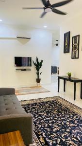 - un salon avec un canapé et une télévision dans l'établissement Kaklah Cherang Homestay, à Kota Bharu