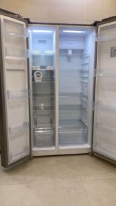 an empty refrigerator with its doors open in a room at Riyadh Salman Villa فيلا in Riyadh