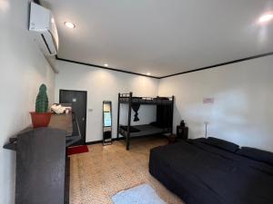 a bedroom with a bed and a flat screen tv at U Hostel Koh Phangan in Haad Rin