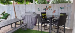 a table and chairs with a grill and a table and a bench at Dancing Iguanas in Oranjestad