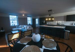 a kitchen and living room with tables and chairs at Bath Street Penthouse in Bath