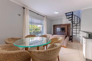 a living room with a glass table and chairs at Excelente Apartamento 190m da Praia de bombinhas - 3 dorms 6 pessoas in Bombinhas