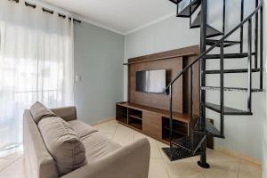 a living room with a couch and a television at Excelente Apartamento 190m da Praia de bombinhas - 3 dorms 6 pessoas in Bombinhas