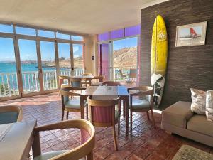un restaurante con mesas y sillas y una tabla de surf en la pared en Lüderitz Nest Hotel en Lüderitz