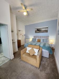 1 dormitorio con cama, sofá y ventilador de techo en The Sea Croft Bed Breakfast & Bar, en Lytham St Annes