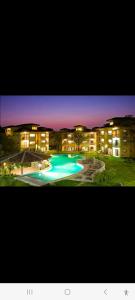 a large apartment building with a swimming pool at night at Beautiful newly refurbished 2 bedroom 2 Bathroom 2nd floor condo in Tamarindo