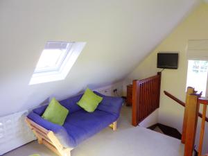 sala de estar con sofá púrpura y 2 almohadas verdes en Pump Lodge, en Weymouth