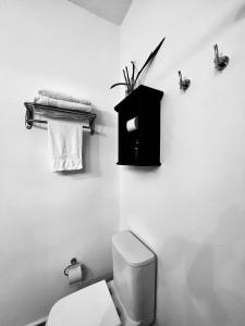 a bathroom with a toilet and a black box on the wall at Viento Azul Guest House in Punta del Este