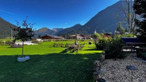 un parque con mesas de picnic y montañas al fondo en Haus Tauern Am See, en Heiterwang