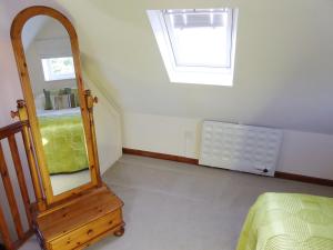 a bedroom with a mirror and a dresser and a window at Pump Lodge in Weymouth