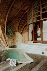 pokój z basenem i budynek z dachem w obiekcie Kini Resort - Oceanfront Bamboo Eco Lodges w mieście Sekongkang