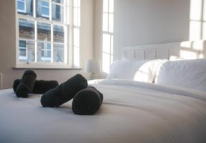 a bedroom with a bed with black slippers on it at Bath Street Penthouse in Bath