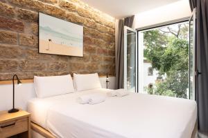 a bedroom with a white bed and a brick wall at Guimerá Family Suites A in Santa Cruz de Tenerife