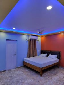 Schlafzimmer mit einem Bett mit blauem Licht in der Unterkunft DayLight Stay in Chennai