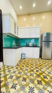 a kitchen with white cabinets and a tile floor at Old Quarter Autumn Hanoi in Hanoi