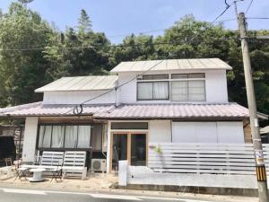 ein weißes Haus mit einem Tisch und Stühlen davor in der Unterkunft Fukuoka - House / Vacation STAY 4898 in Fukuoka