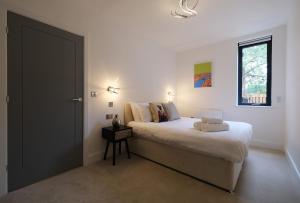 una camera con un grande letto e una finestra di Brand New Ground Floor Apartment with Balcony a Londra