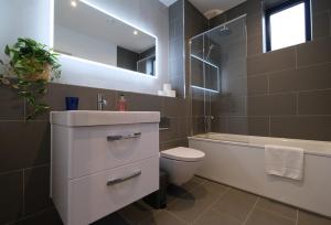e bagno con lavandino, servizi igienici e vasca. di Brand New Ground Floor Apartment with Balcony a Londra