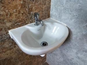 a white sink in a bathroom with a fosset at DayLight Stay in Chennai