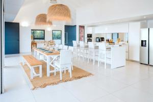 a kitchen and dining room with white tables and white chairs at Villas Vista Del Mar in Sainte-Anne