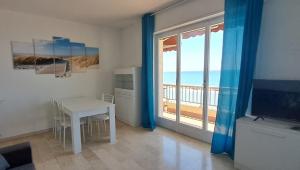 a living room with a table and a view of the ocean at Casa Anna appartamento fronte mare Ventimiglia in Ventimiglia
