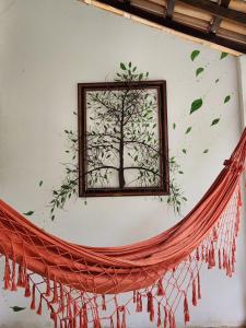 una pintura de un árbol en una pared con una red en Pousada Vila Gaia, en Santo André