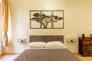 a bedroom with a bed with three pictures on the wall at Maison Piazza di Spagna in Rome