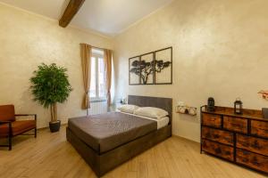 um quarto com uma cama, uma cadeira e uma cómoda em Maison Piazza di Spagna em Roma