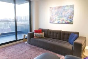 a living room with a couch and a painting at Modern Spacious 2BD2Bath - Stunning City Views! in Melbourne