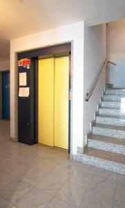 einen Flur mit gelben Türen und Treppen in einem Gebäude in der Unterkunft Gaia Apartment un gioiello in Grado