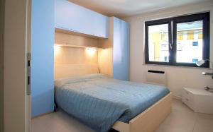 ein kleines Schlafzimmer mit einem Bett und einem Fenster in der Unterkunft Gaia Apartment un gioiello in Grado