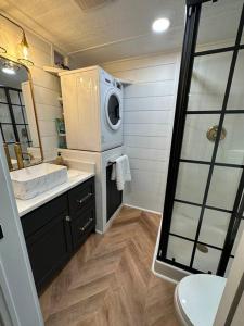 La salle de bains est pourvue d'un lavabo et d'un lave-linge. dans l'établissement New Cute “Trinity” Tiny Home, 