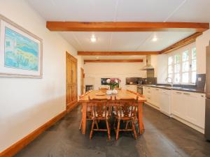 a large kitchen with a wooden table and chairs at Carneadon Farmhouse in Launceston