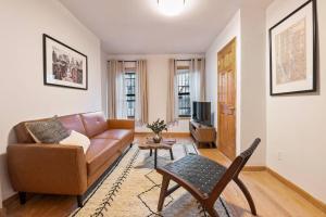 ein Wohnzimmer mit einem Sofa und einem Tisch in der Unterkunft Delightful 2BR Apartment in NYC! in New York