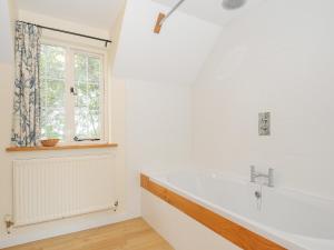 a white bathroom with a sink and a window at Carneadon Farmhouse in Launceston