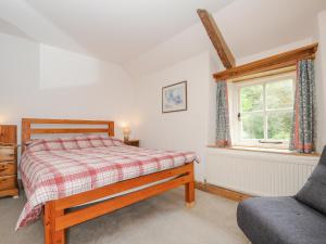 a bedroom with a bed and a window and a chair at Carneadon Farmhouse in Launceston