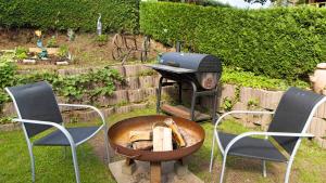 a grill with two chairs and a table with a grill at Haus Zum Sternen in Vöhrenbach