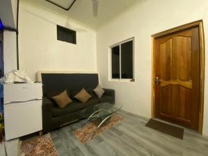 een woonkamer met een bank en een deur bij Rashuthere Maldives in Rasdu