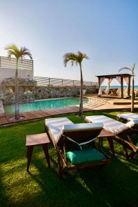 un grupo de tumbonas y una piscina en Carlore Hotel Taíba, en Taíba
