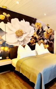 1 dormitorio con 1 cama con una pintura floral en la pared en Ferienwohnungen Krüger ''Apartment Finn", en Michelstadt