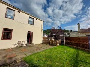 a yard with a house and a fence at Cosy flat in Innerleithen in Innerleithen