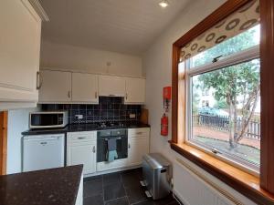 cocina con electrodomésticos blancos y ventana grande en Cosy flat in Innerleithen en Innerleithen