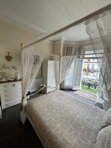 a bedroom with a canopy bed and a window at The Little Emily - Room Only in Great Yarmouth