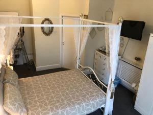 a bedroom with a canopy bed and a dresser at The Little Emily - Room Only in Great Yarmouth