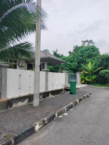 a palm tree in front of a house with a trash can at Creatills luxury homestay Kulim & hi-tech in Kulim