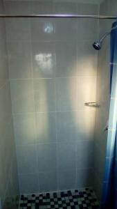 een badkamer met een douche en een zwart-witte tegel bij Mosas Home in Serowe