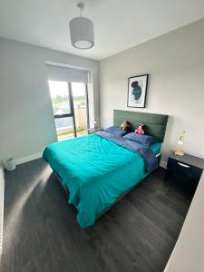 a bedroom with a green bed with two teddy bears on it at Private Ensuite Room (King size bed) in Dublin