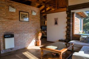 uma sala de estar com uma parede de tijolos em El Rodeo Apart Cabañas em Santa Rosa de Calamuchita