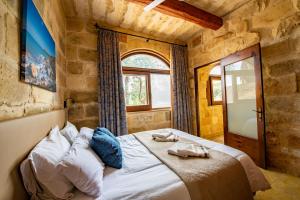 a bedroom with a bed in a stone wall at Villa Soldanis 6 Bedroom Villa with private pool in Xagħra