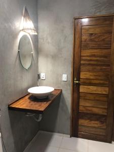 uma casa de banho com um lavatório e um espelho num balcão de madeira em Suite Duplo Wind Jeri em Jericoacoara